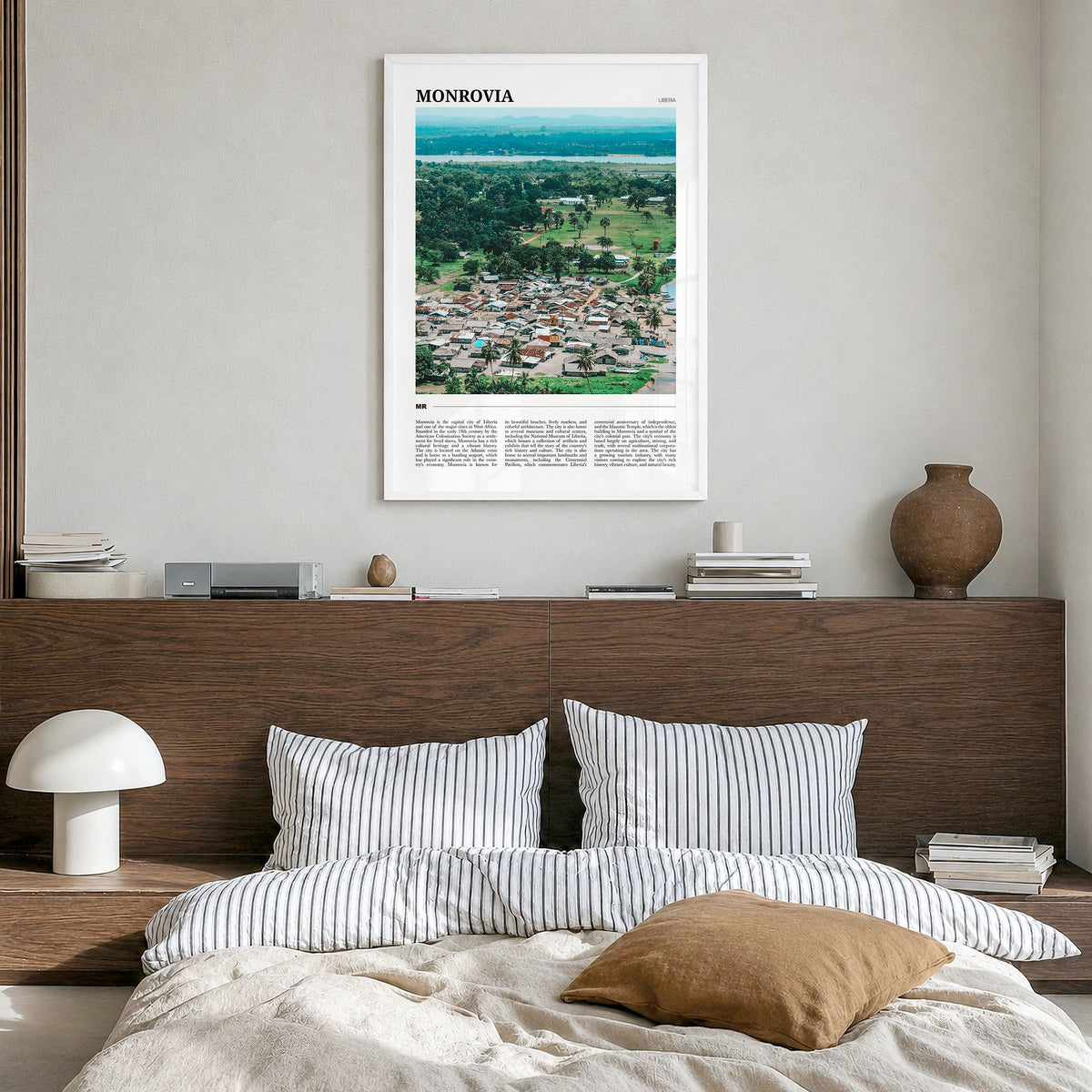 Monrovia Travel No 2 Poster in a white wood frame, hanging in a bedroom