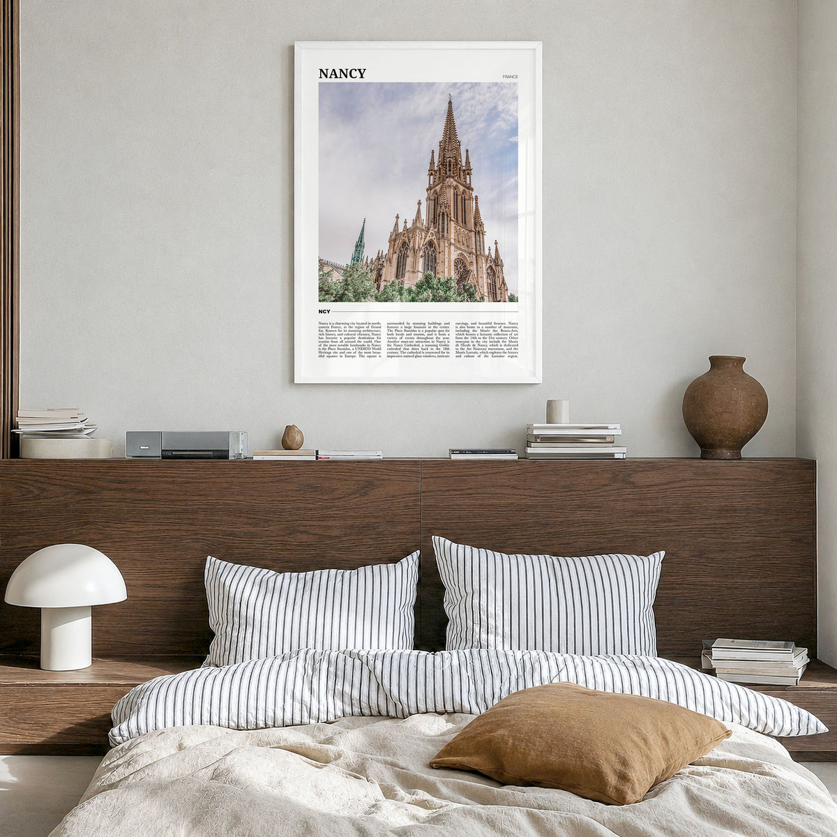 Nancy Travel Poster in a white wood frame, hanging in a bedroom
