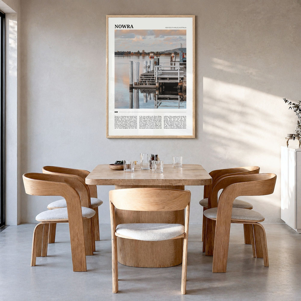 Nowra Travel Poster in a natural wood frame, hanging in a dining room