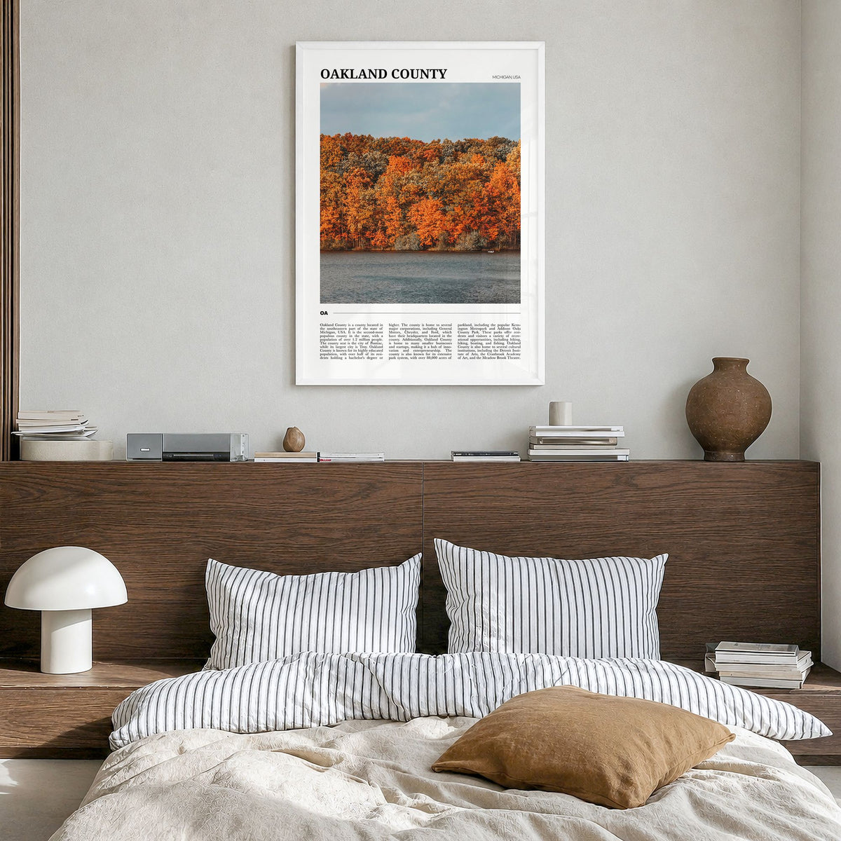 Oakland County Travel Poster in a white wood frame, hanging in a bedroom