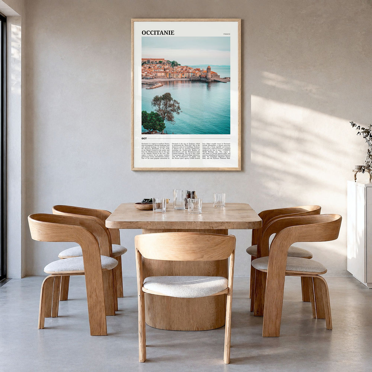 Occitanie Travel Poster in a natural wood frame, hanging in a dining room