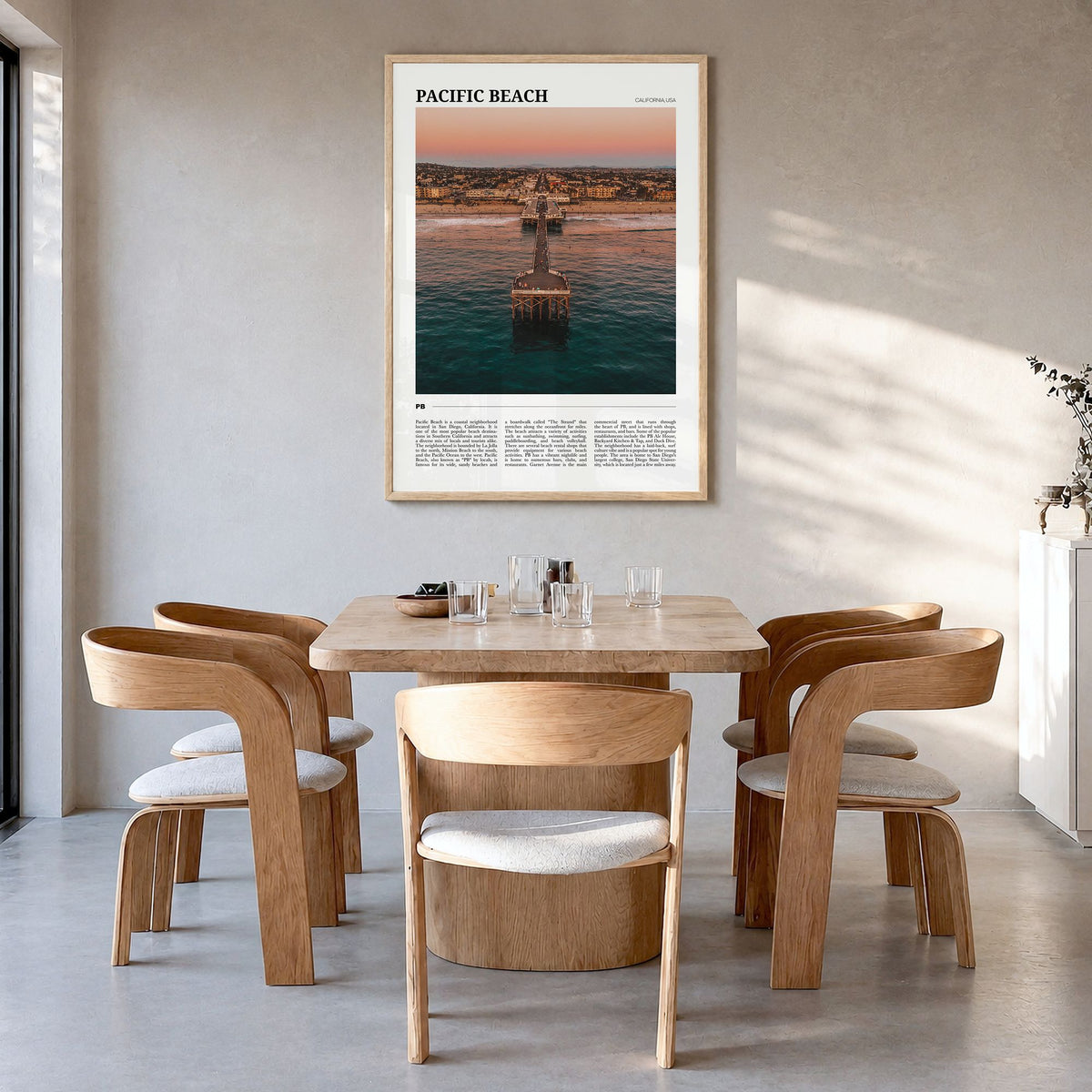 Pacific Beach Travel Poster in a natural wood frame, hanging in a dining room