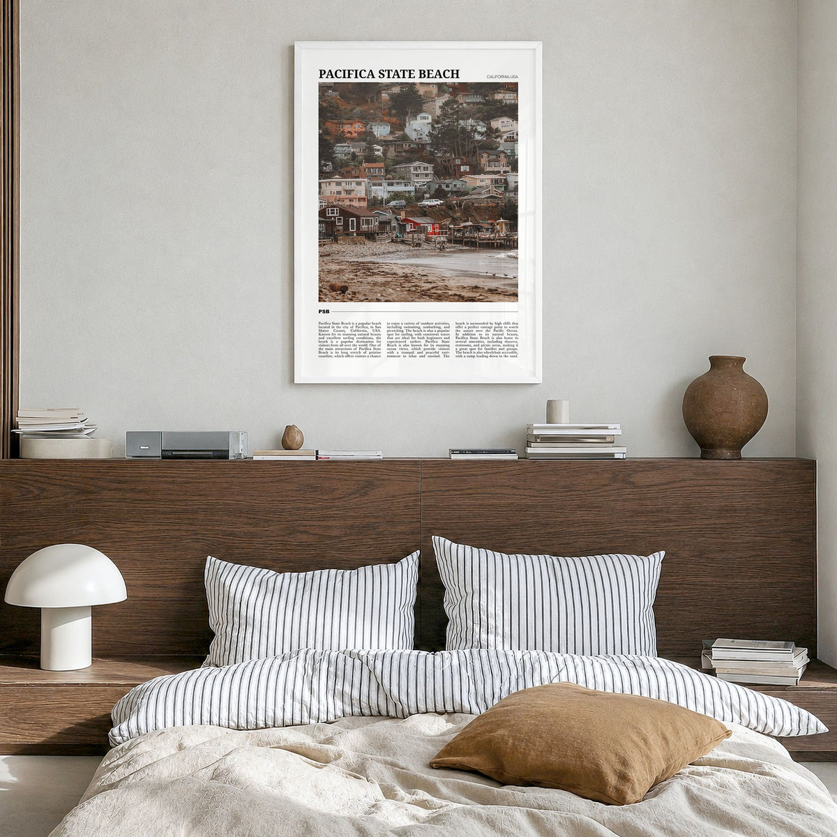 Pacifica State Beach Travel Poster in a white wood frame, hanging in a bedroom