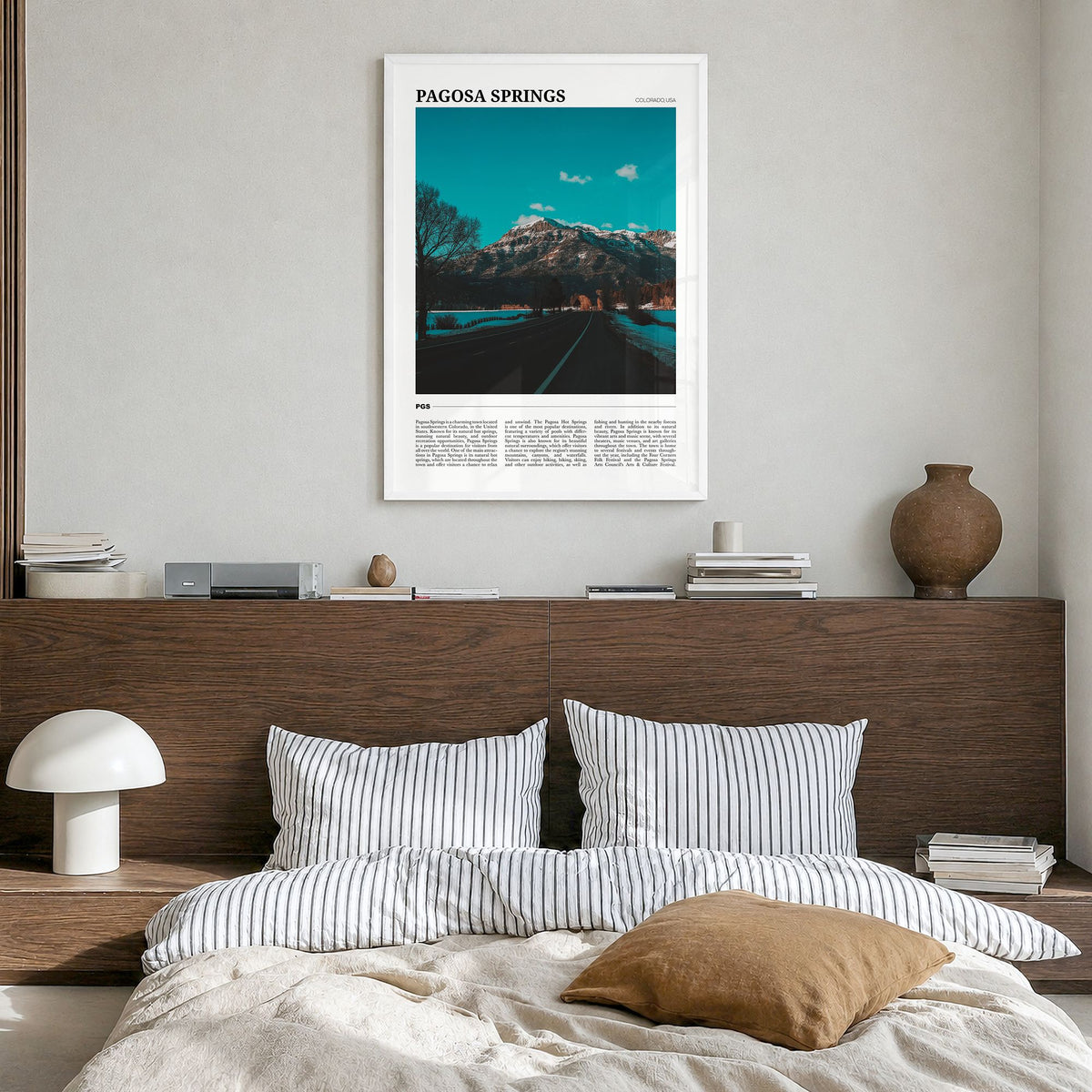 Pagosa Springs Travel Poster in a white wood frame, hanging in a bedroom