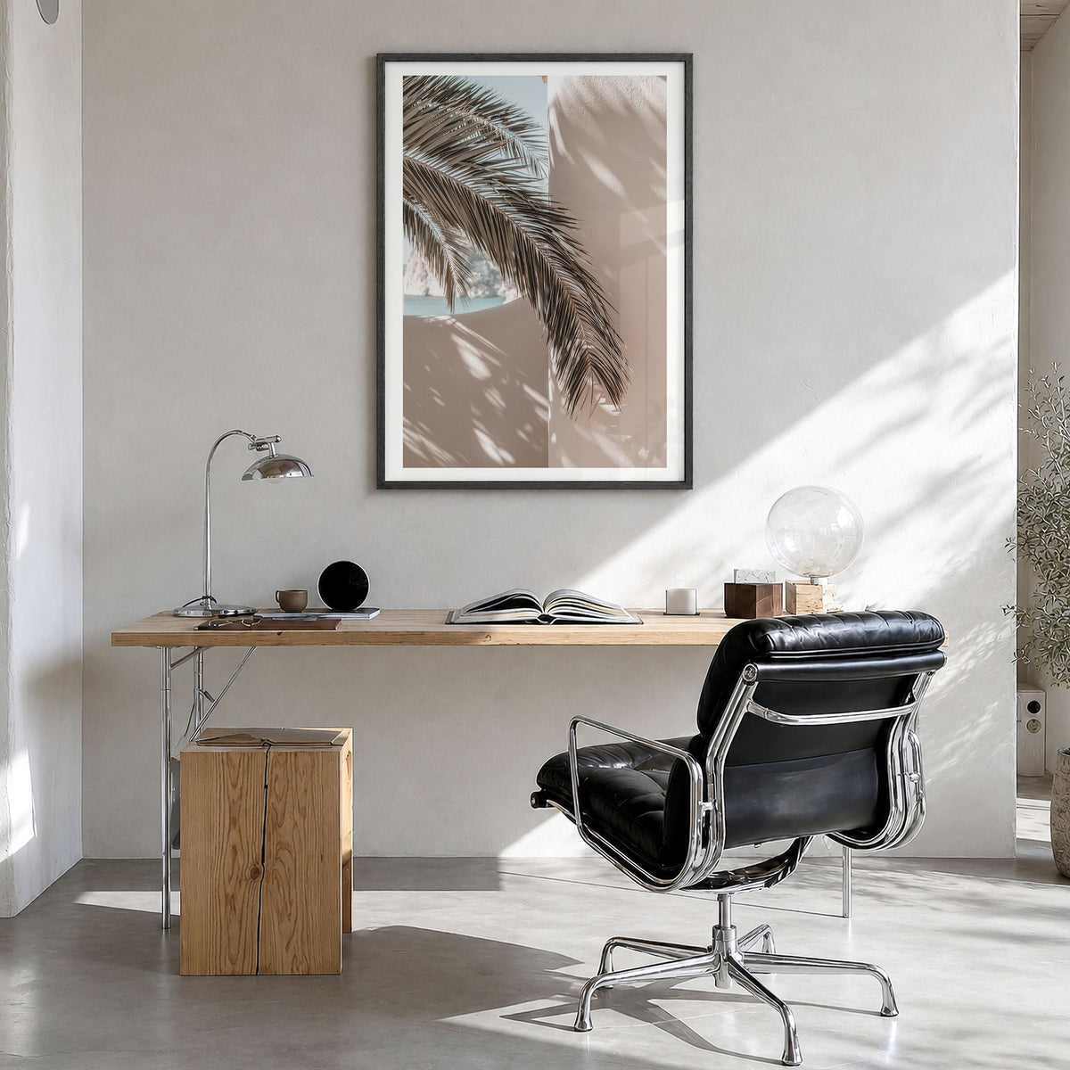 Palm Leaf Shadow Photo Poster in a black wood frame, hanging in a bright home office, white border