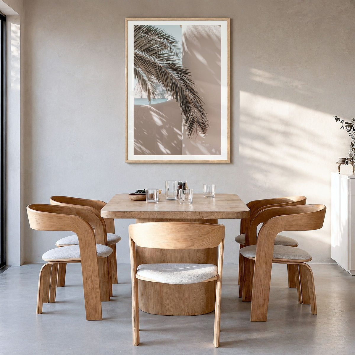 Palm Leaf Shadow Photo Poster in a natural wood frame, hanging in a dining room, white border
