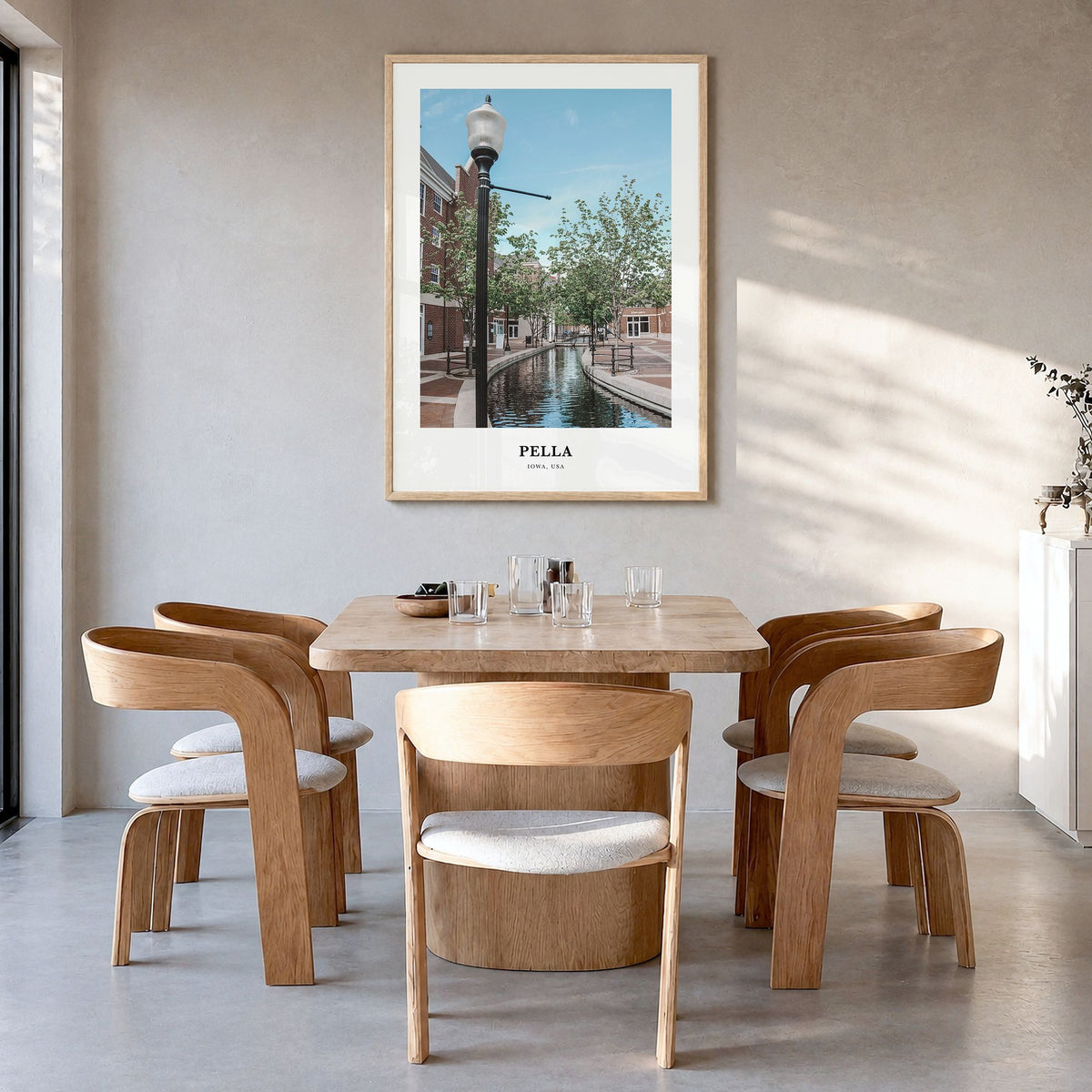 Pella, Iowa Classic Poster in a natural wood frame, hanging in a dining room