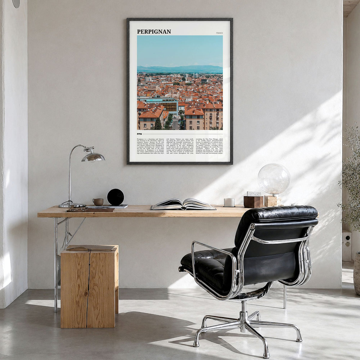 Perpignan Travel Poster in a black wood frame, hanging in a bright home office