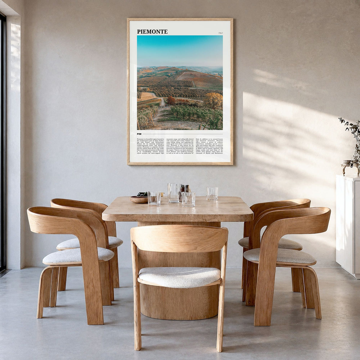 Piemonte Travel Poster in a natural wood frame, hanging in a dining room