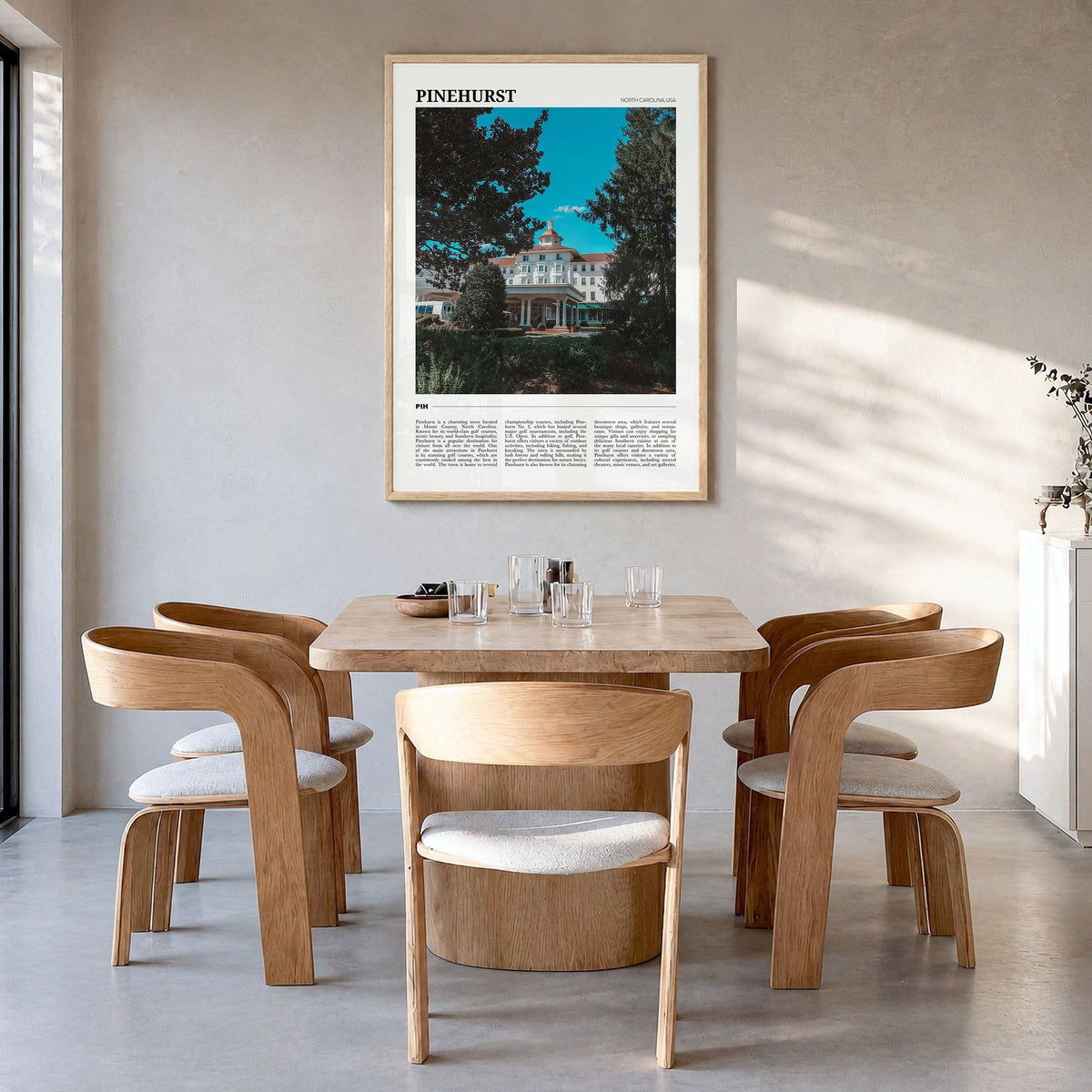 Pinehurst Travel Poster in a natural wood frame, hanging in a dining room