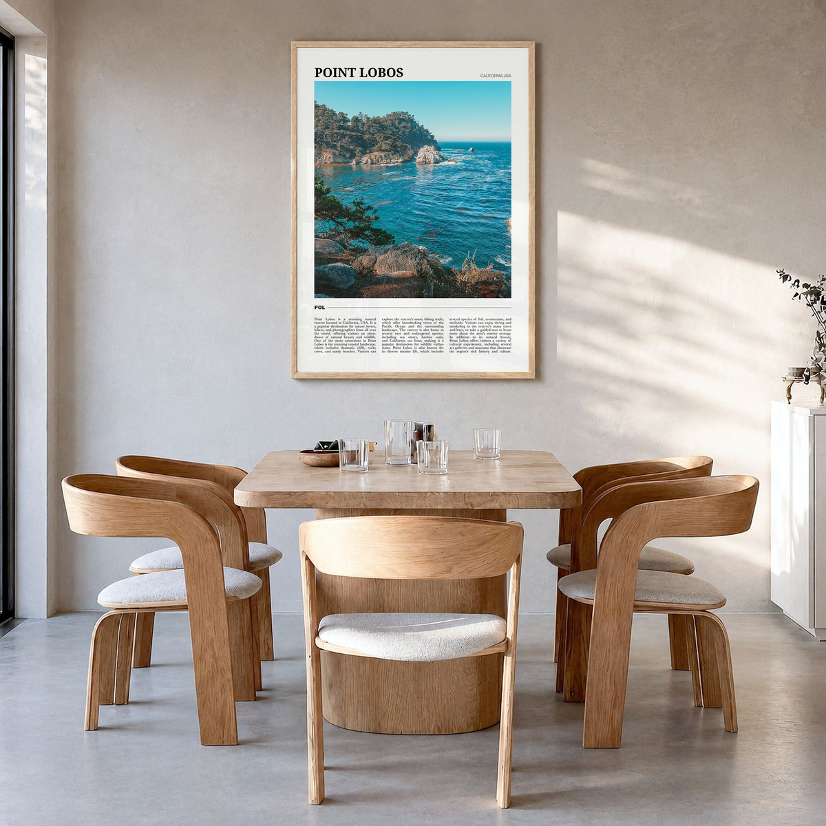 Point Lobos Travel Poster in a natural wood frame, hanging in a dining room