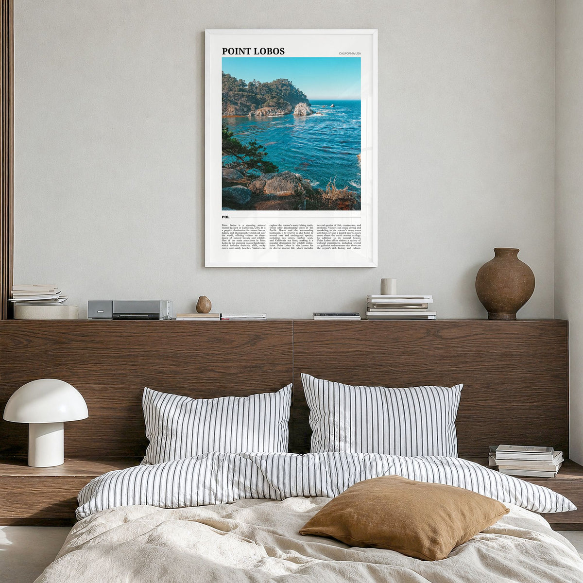 Point Lobos Travel Poster in a white wood frame, hanging in a bedroom