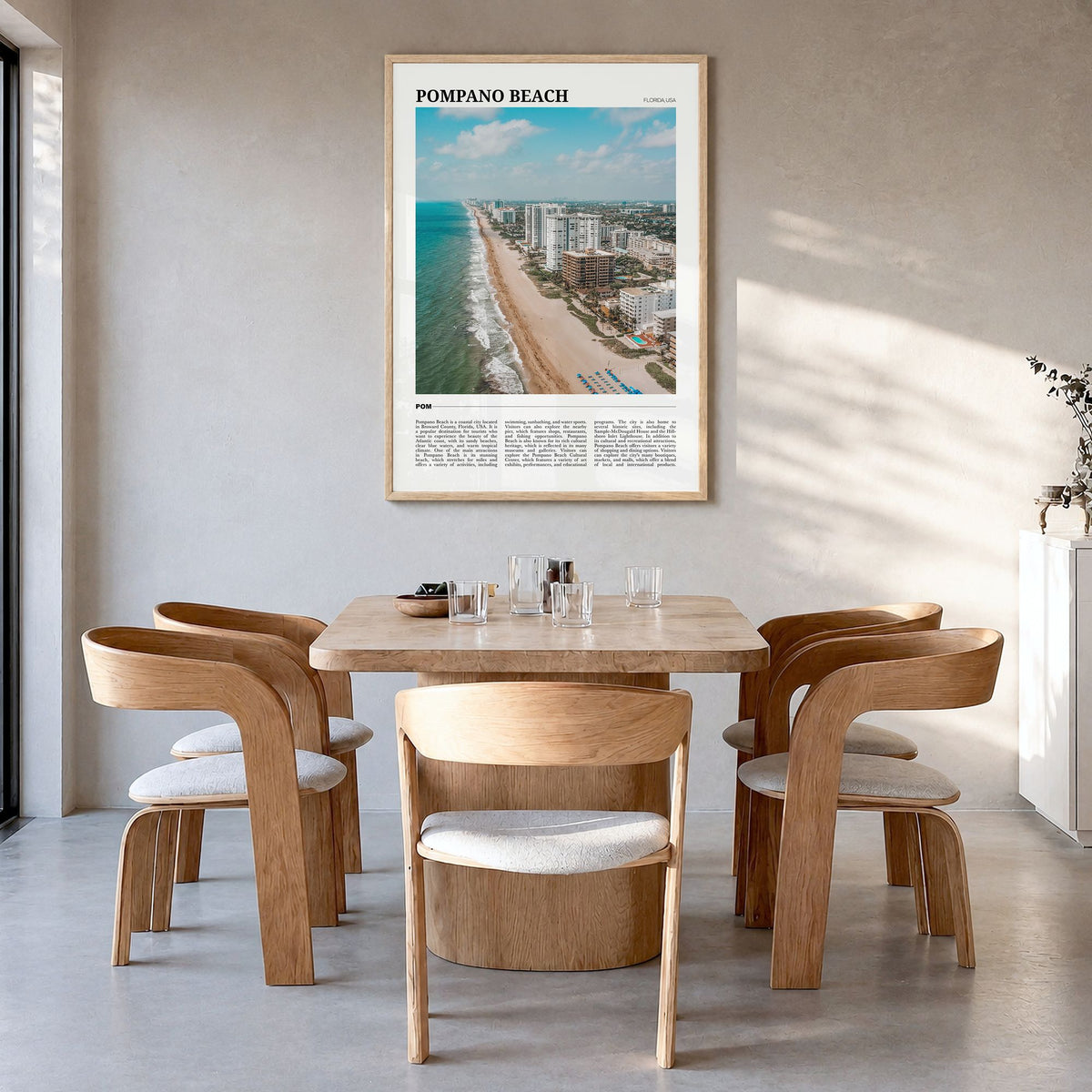Pompano Beach Travel Poster in a natural wood frame, hanging in a dining room