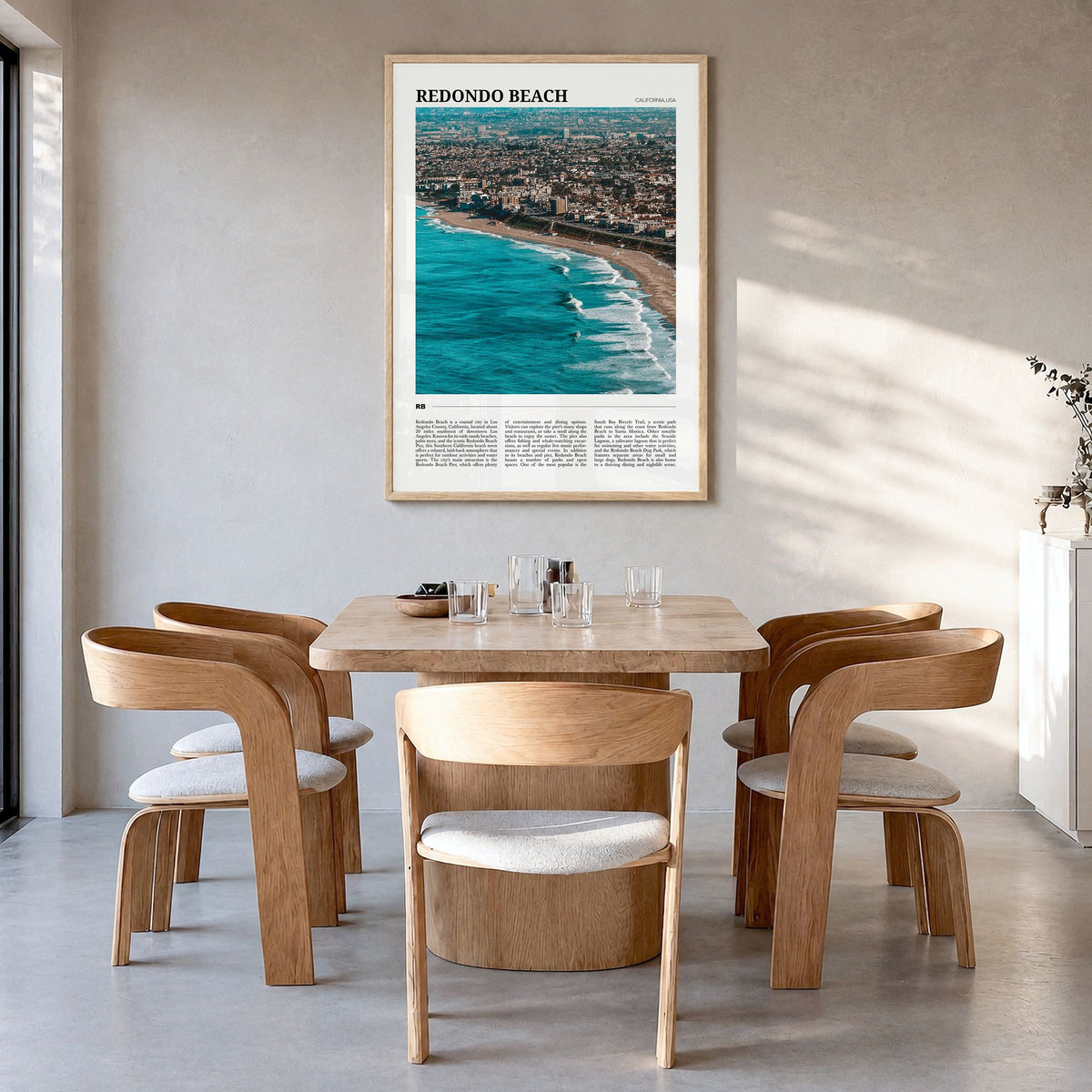 Redondo Beach Travel Poster in a natural wood frame, hanging in a dining room