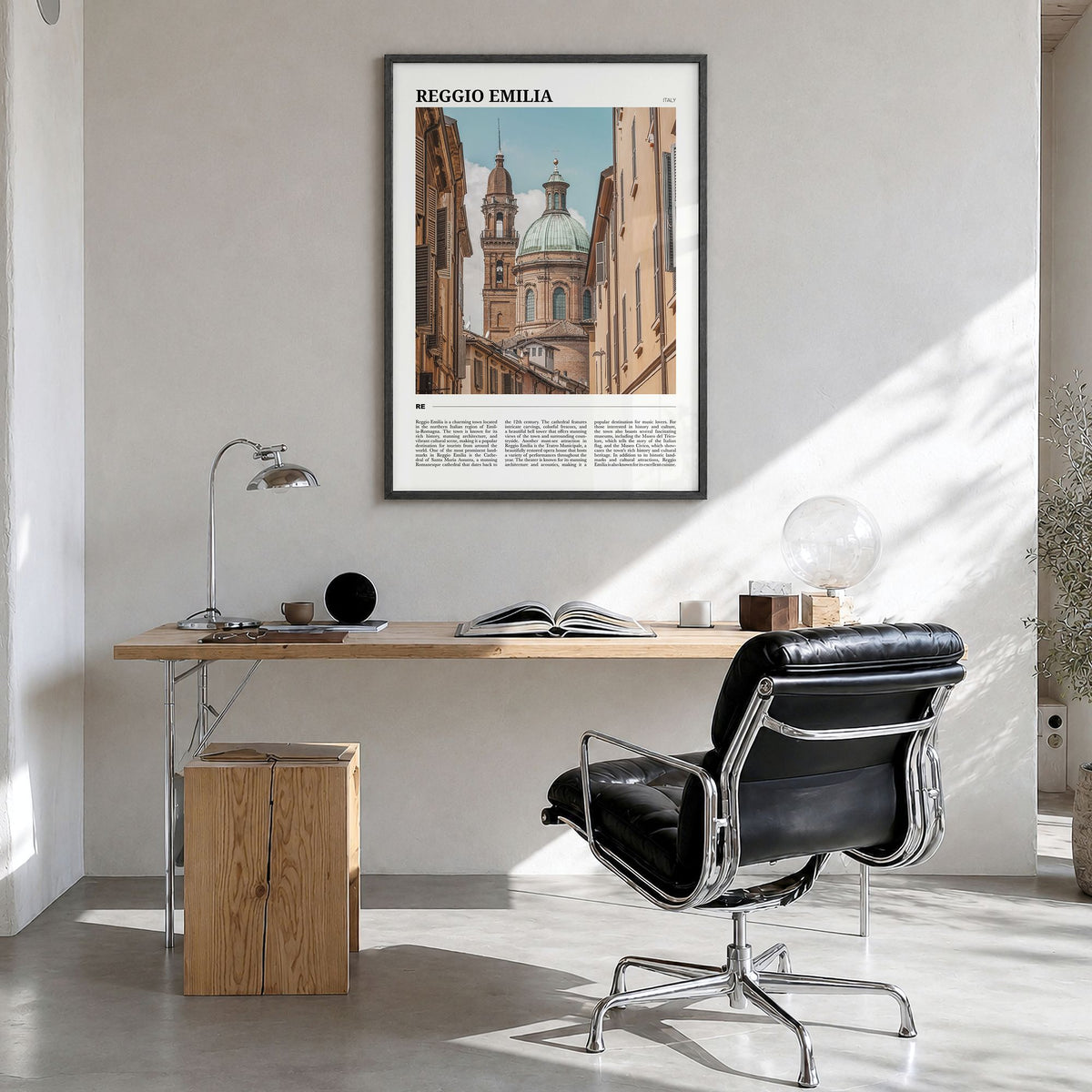 Reggio Emilia Travel Poster in a black wood frame, hanging in a bright home office