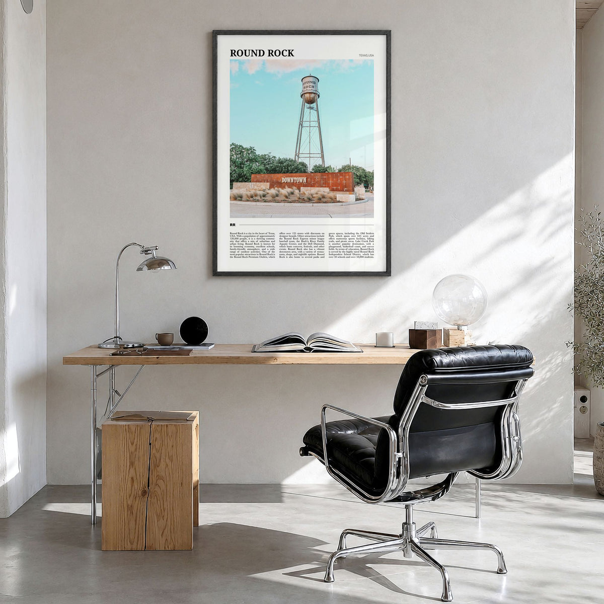 Round Rock Travel Poster in a black wood frame, hanging in a bright home office