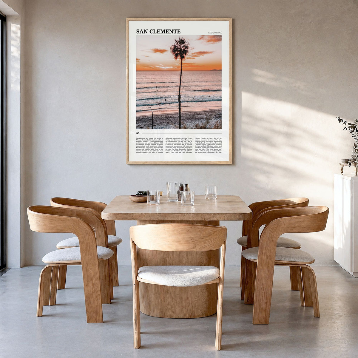 San Clemente Travel Poster in a natural wood frame, hanging in a dining room