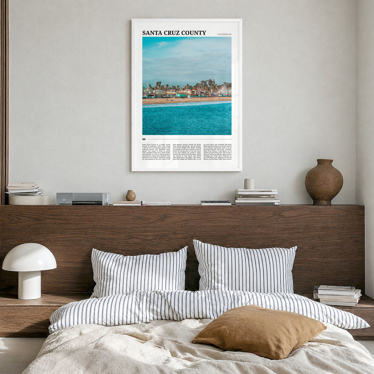 Santa Cruz County Travel Poster in a white wood frame, hanging in a bedroom