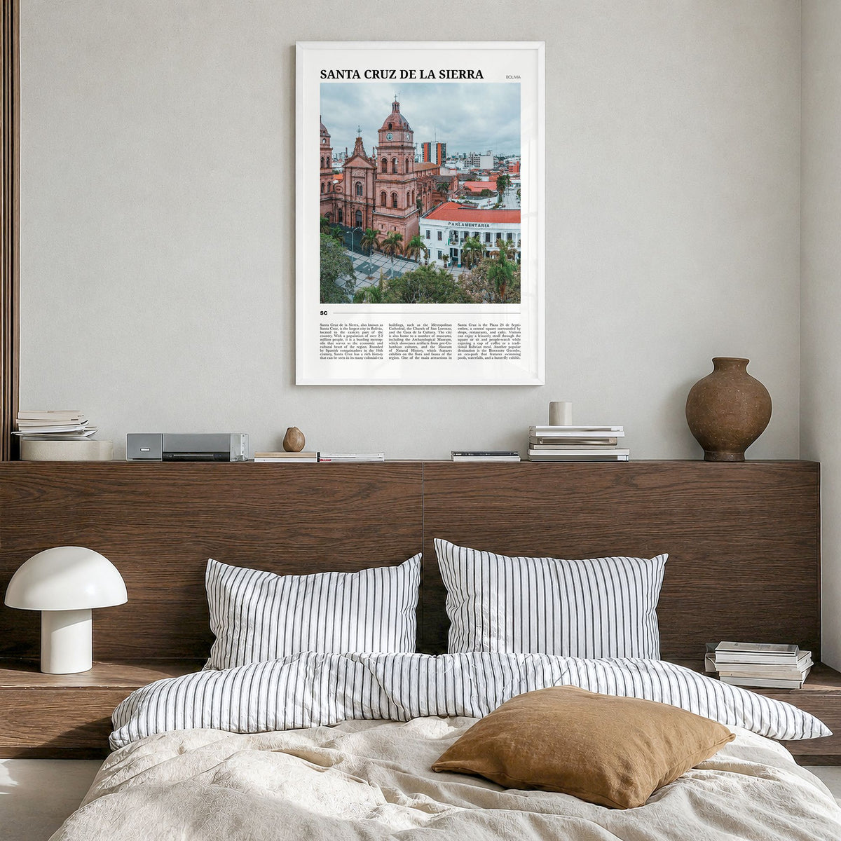Santa Cruz de la Sierra Travel Poster in a white wood frame, hanging in a bedroom