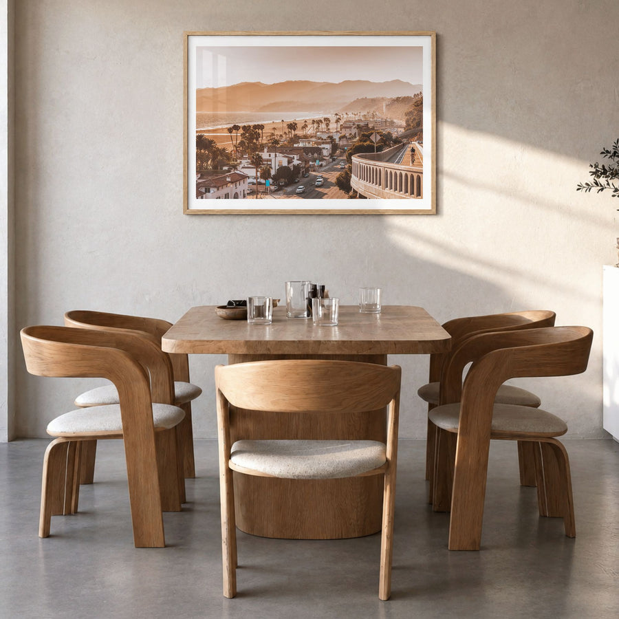 Santa Monica Photo Poster in a natural wood frame, hanging in a dining room, white border