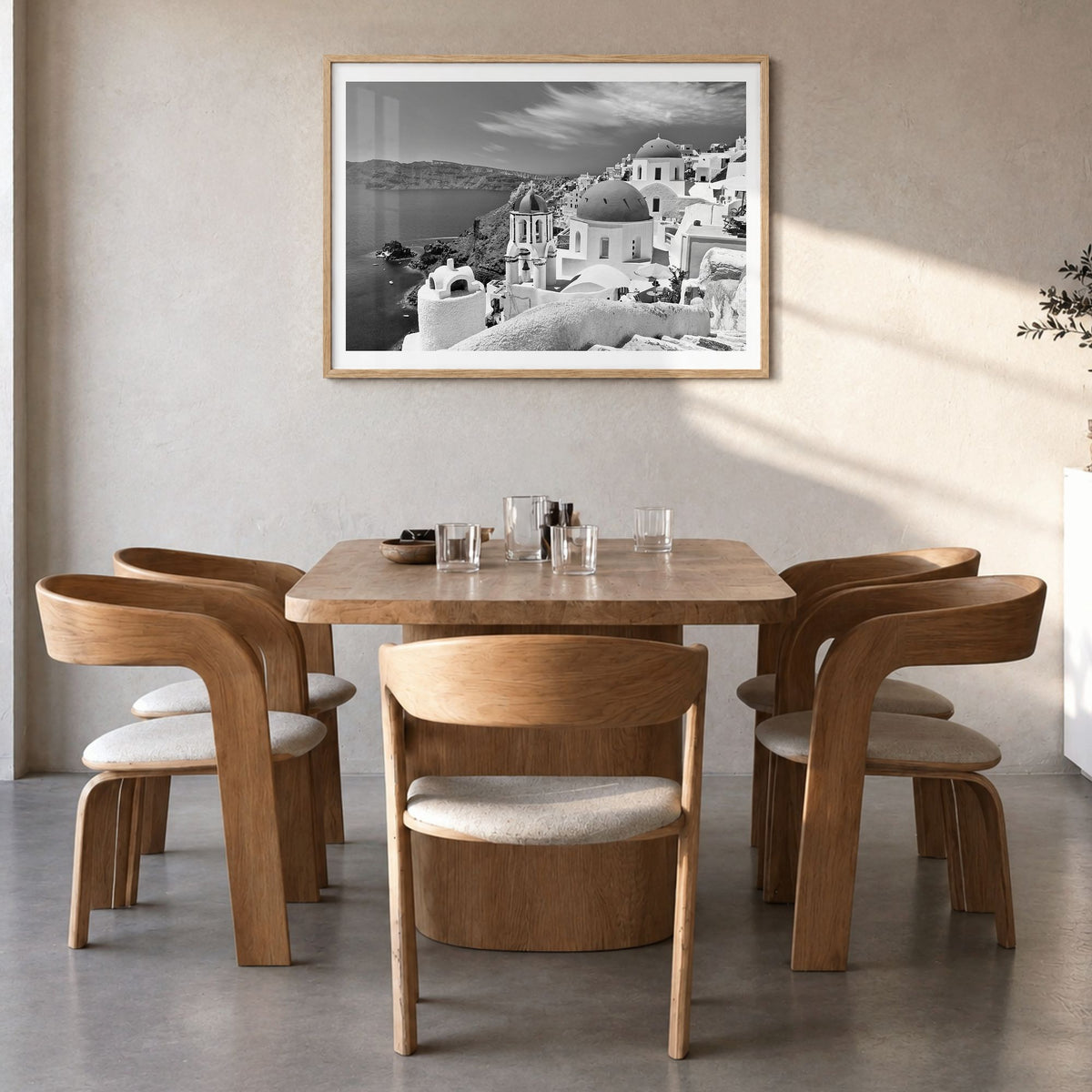 Santorini Photo Poster in a natural wood frame, hanging in a dining room, white border