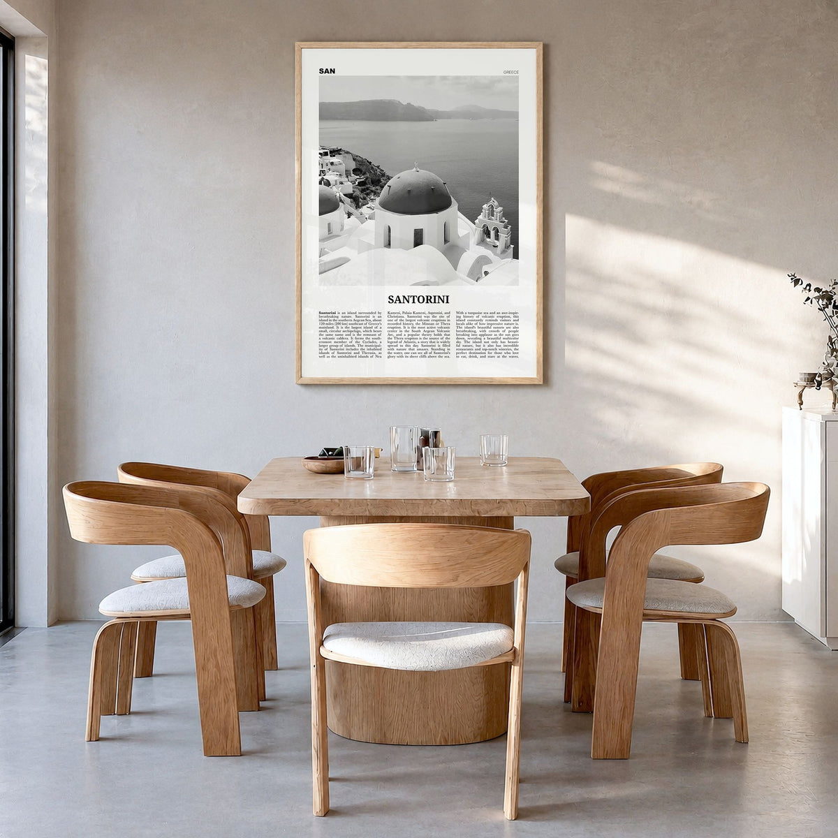 Santorini Newspaper Poster in a natural wood frame, hanging in a dining room