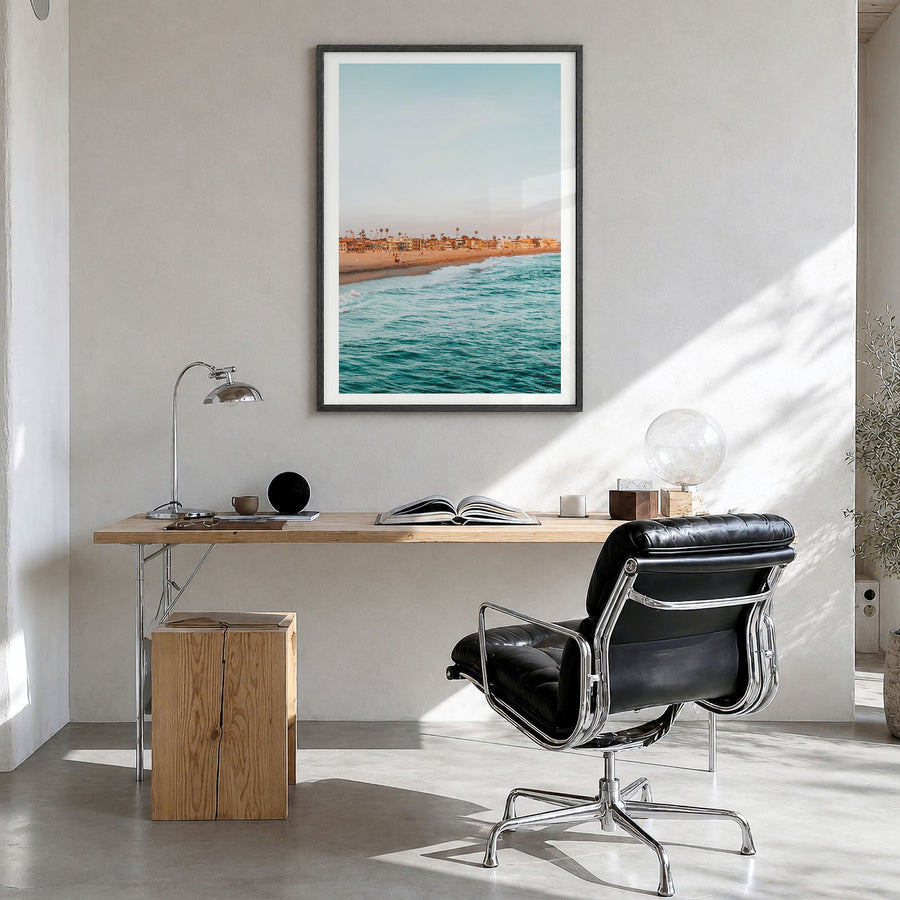 Seal Beach Photo Poster in a black wood frame, hanging in a bright home office, white border
