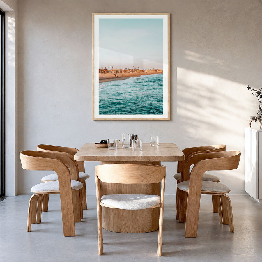 Seal Beach Photo Poster in a natural wood frame, hanging in a dining room, white border