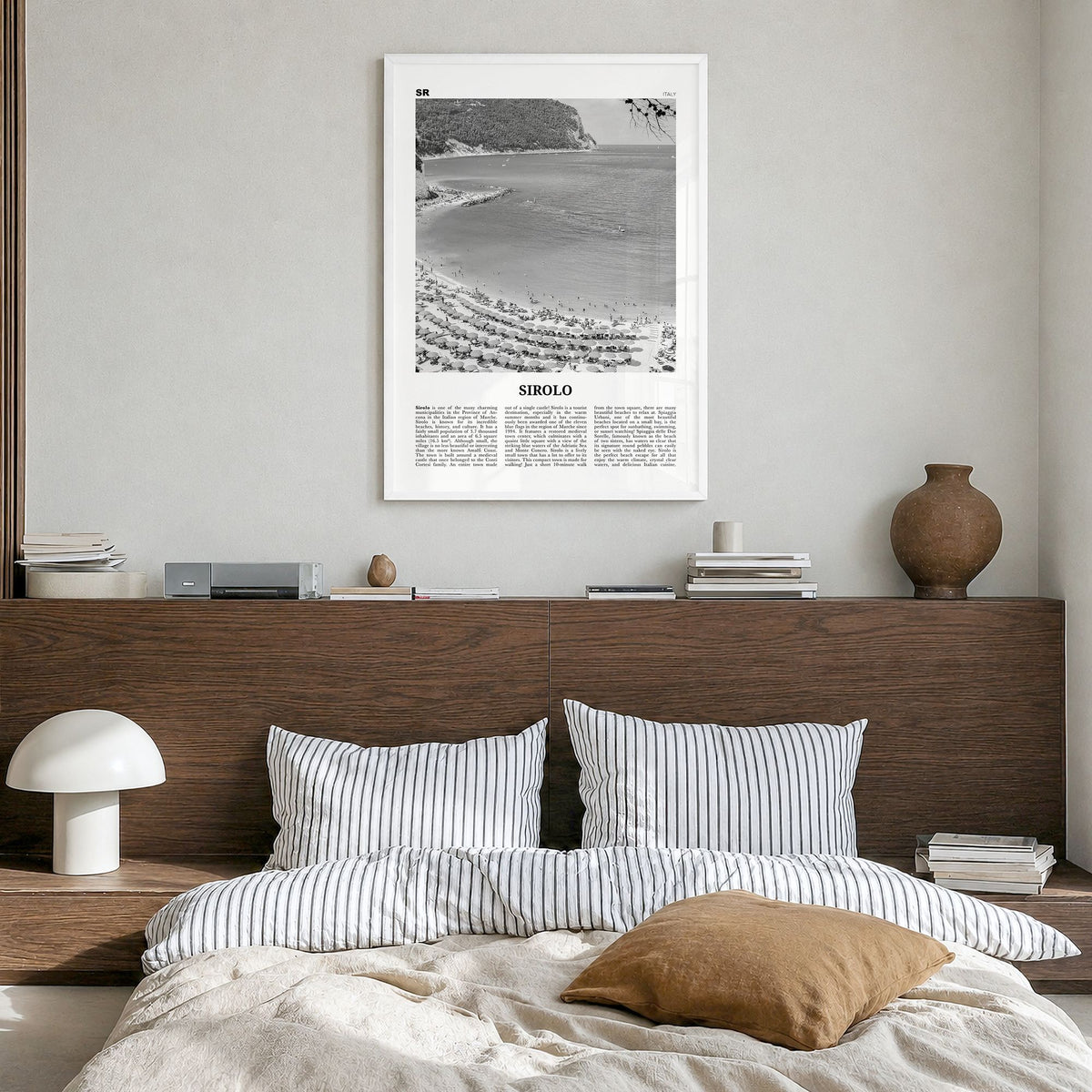 Sirolo Newspaper Poster in a white wood frame, hanging in a bedroom