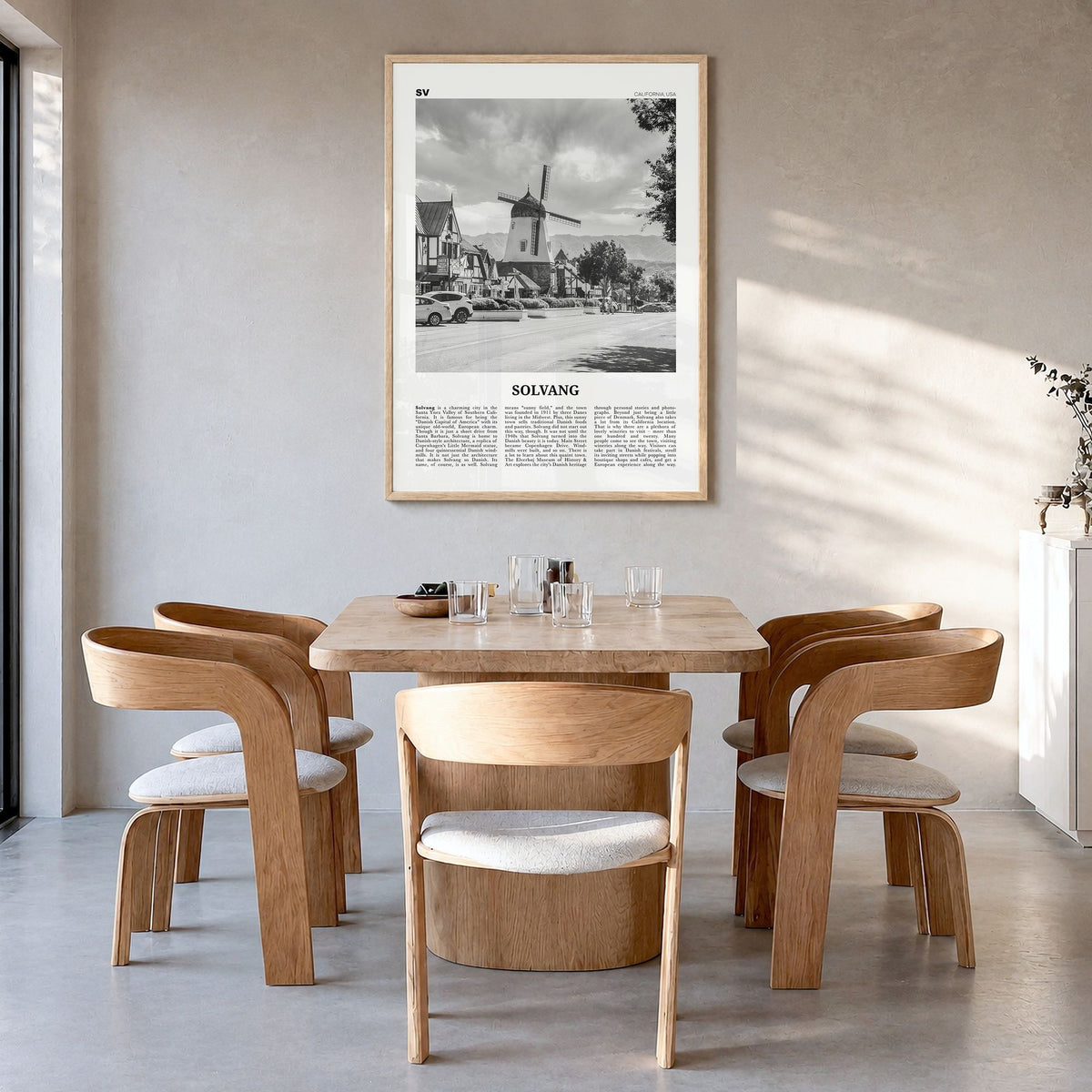 Solvang Newspaper Poster in a natural wood frame, hanging in a dining room