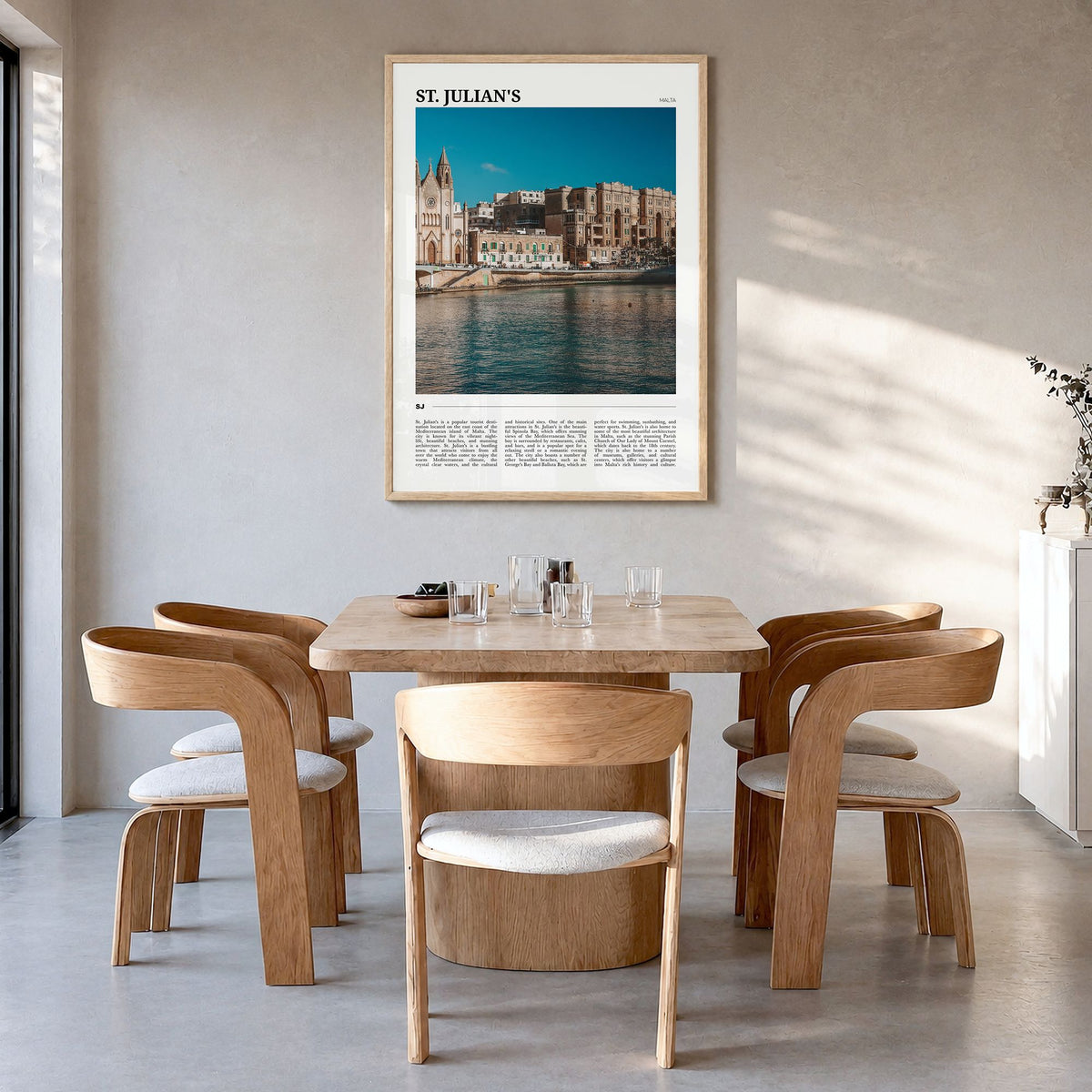 St. Julian's Travel Poster in a natural wood frame, hanging in a dining room