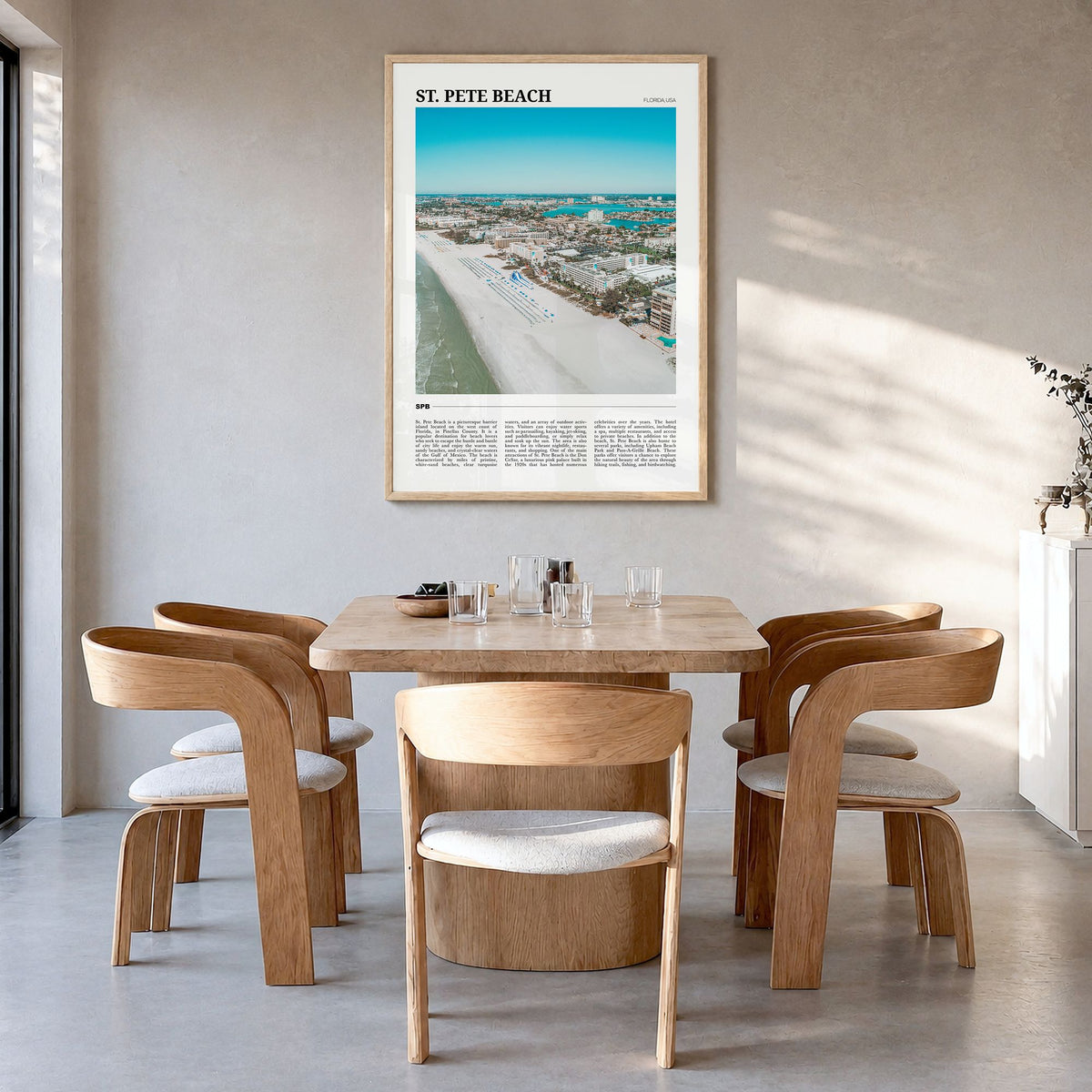 St. Pete Beach Travel Poster in a natural wood frame, hanging in a dining room