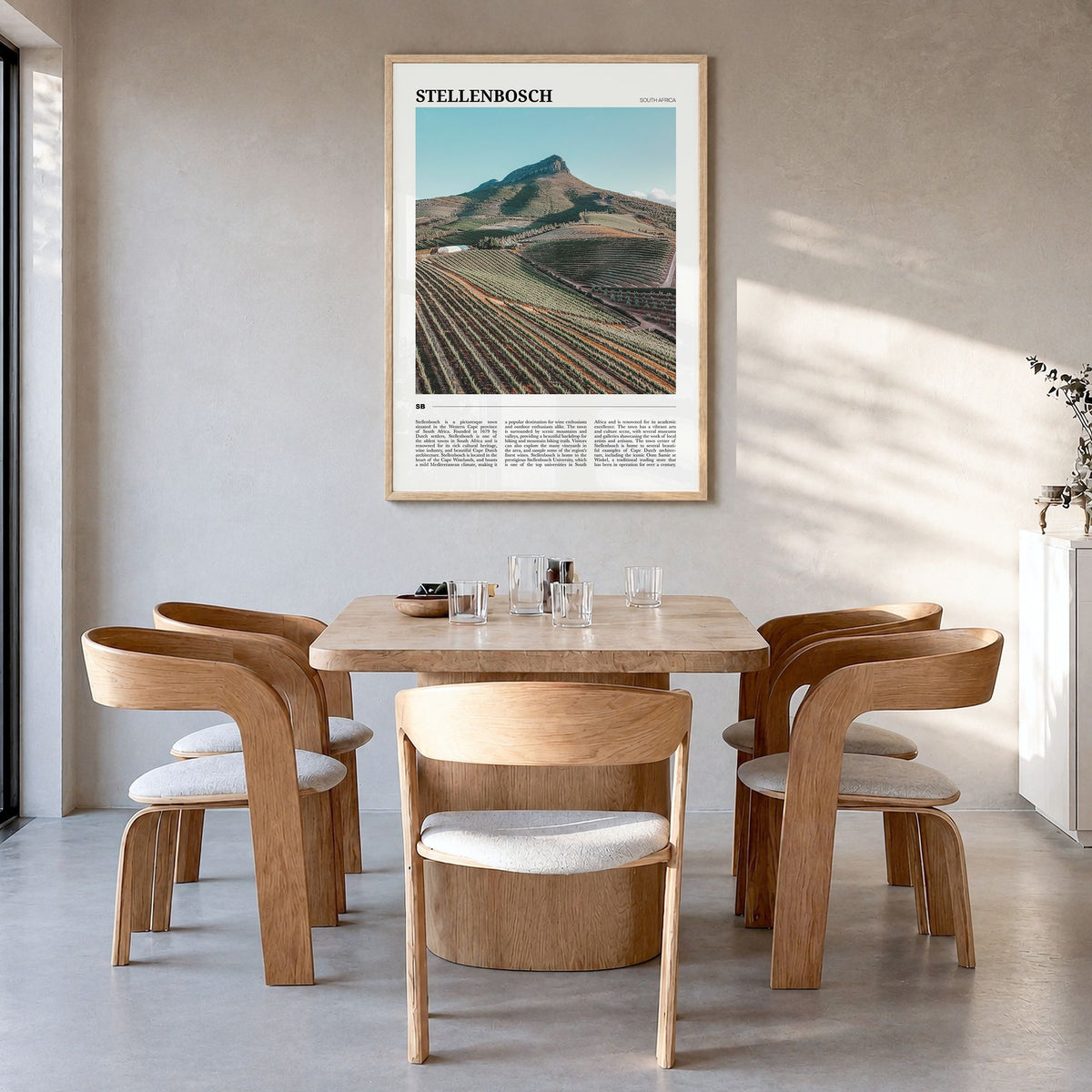 Stellenbosch Travel Poster in a natural wood frame, hanging in a dining room