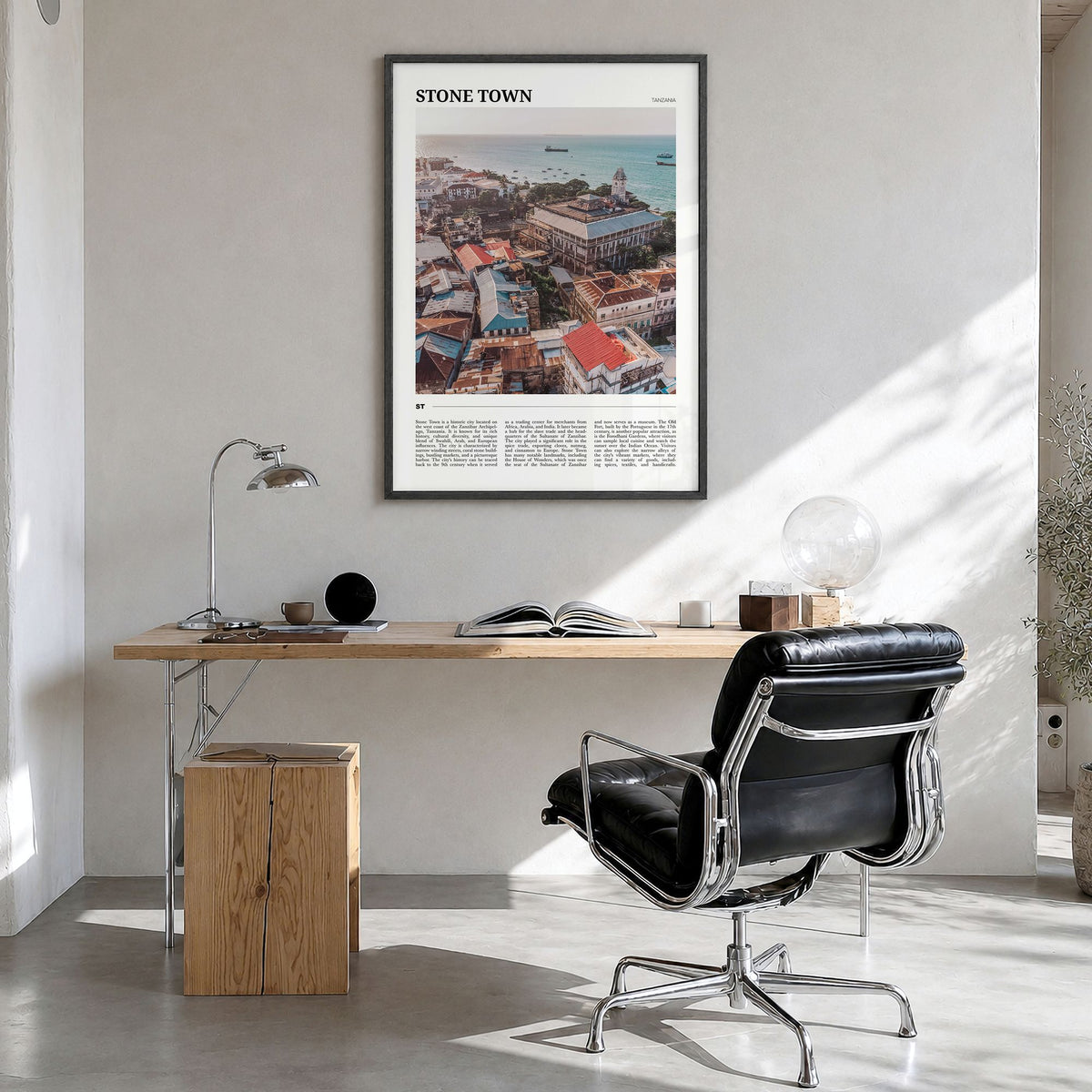 Stone Town Travel Poster in a black wood frame, hanging in a bright home office