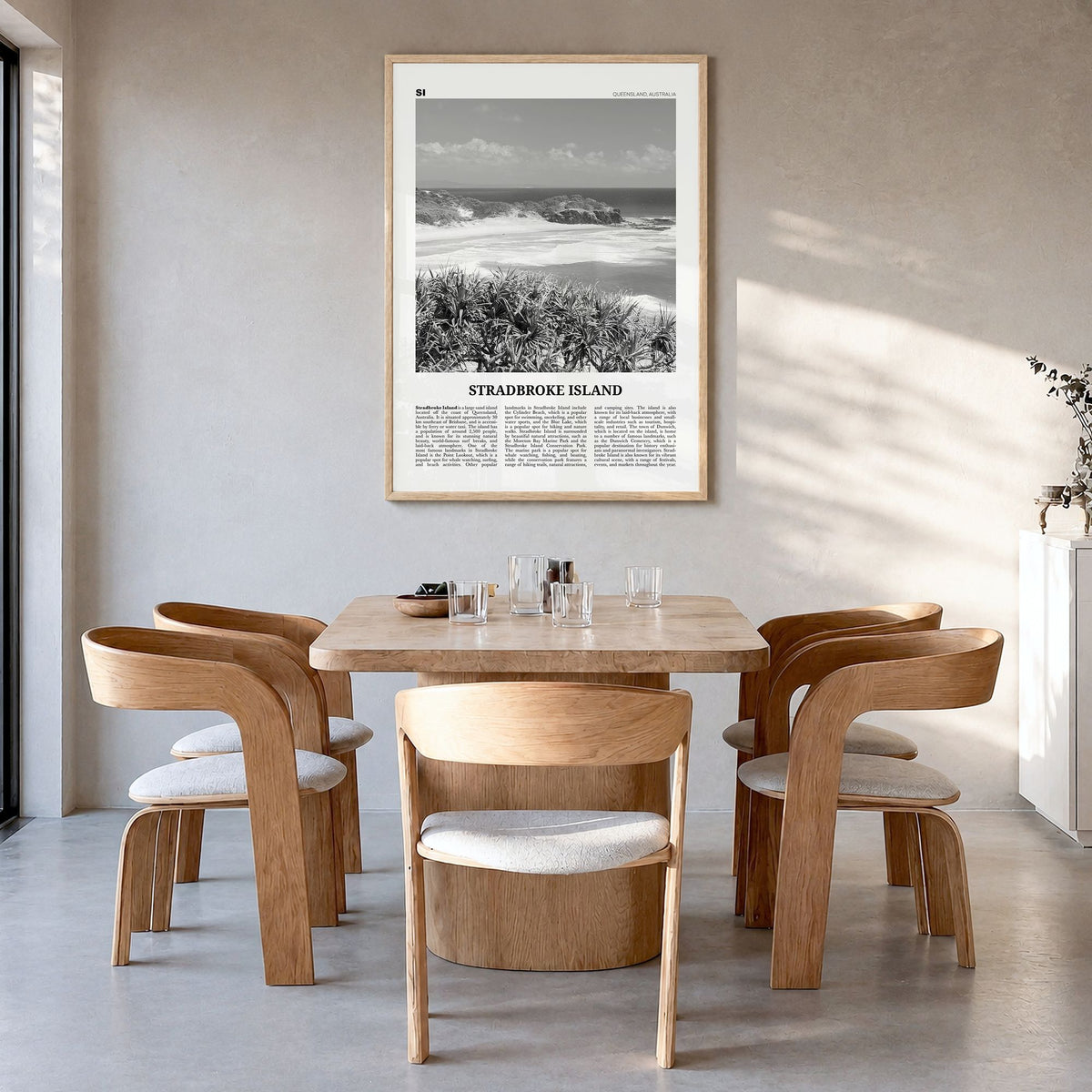 Stradbroke Island Newspaper Poster in a natural wood frame, hanging in a dining room