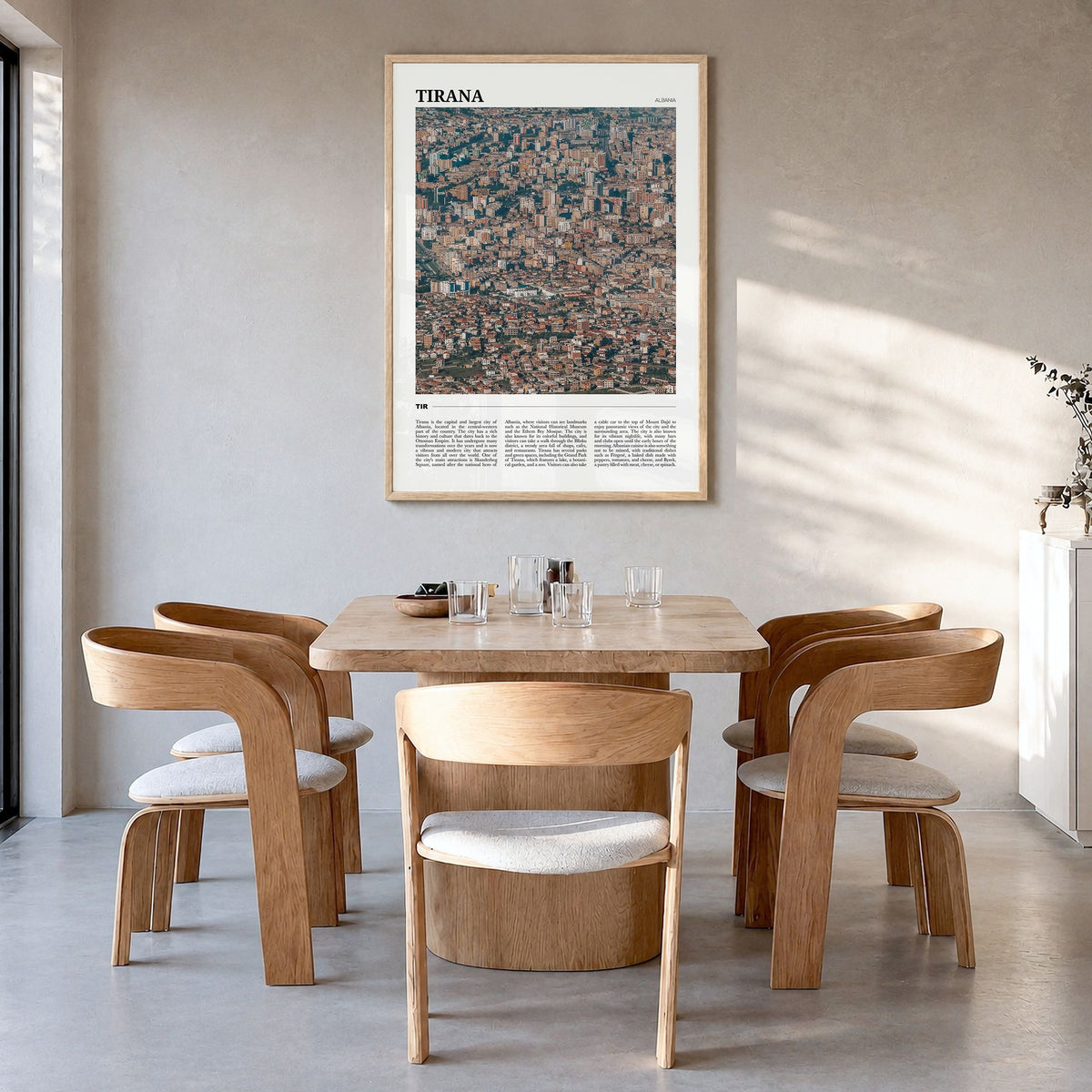Tirana Travel Poster in a natural wood frame, hanging in a dining room