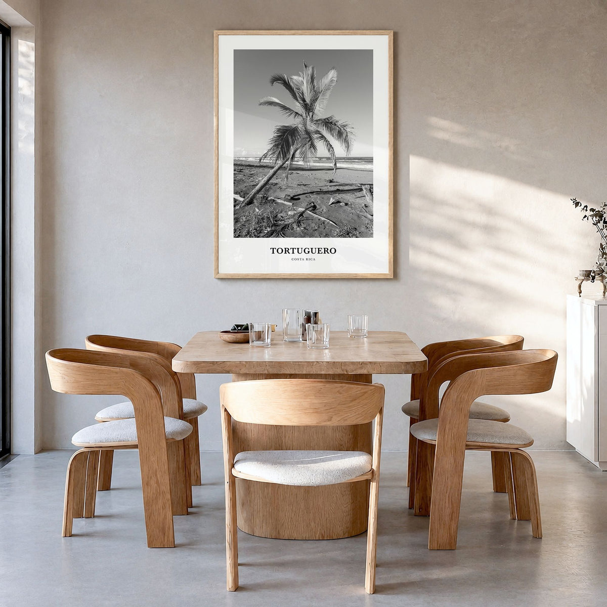Tortuguero Classic Poster in a natural wood frame, hanging in a dining room