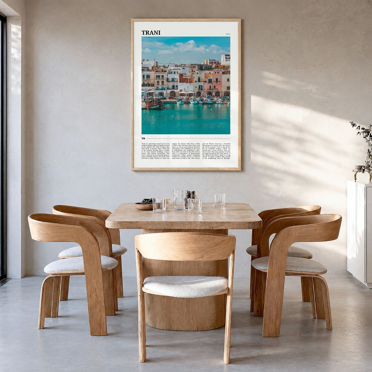Trani Travel Poster in a natural wood frame, hanging in a dining room