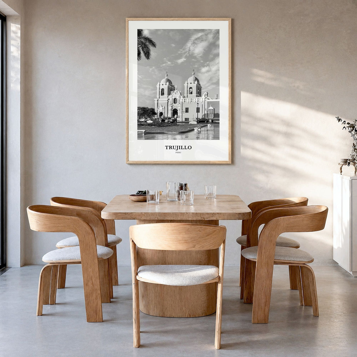 Trujillo Classic Poster in a natural wood frame, hanging in a dining room