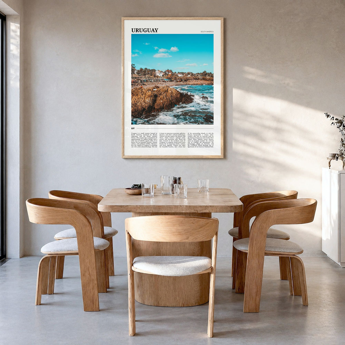 Uruguay Travel Poster in a natural wood frame, hanging in a dining room