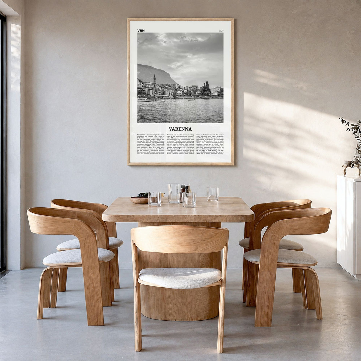 Varenna Newspaper Poster in a natural wood frame, hanging in a dining room