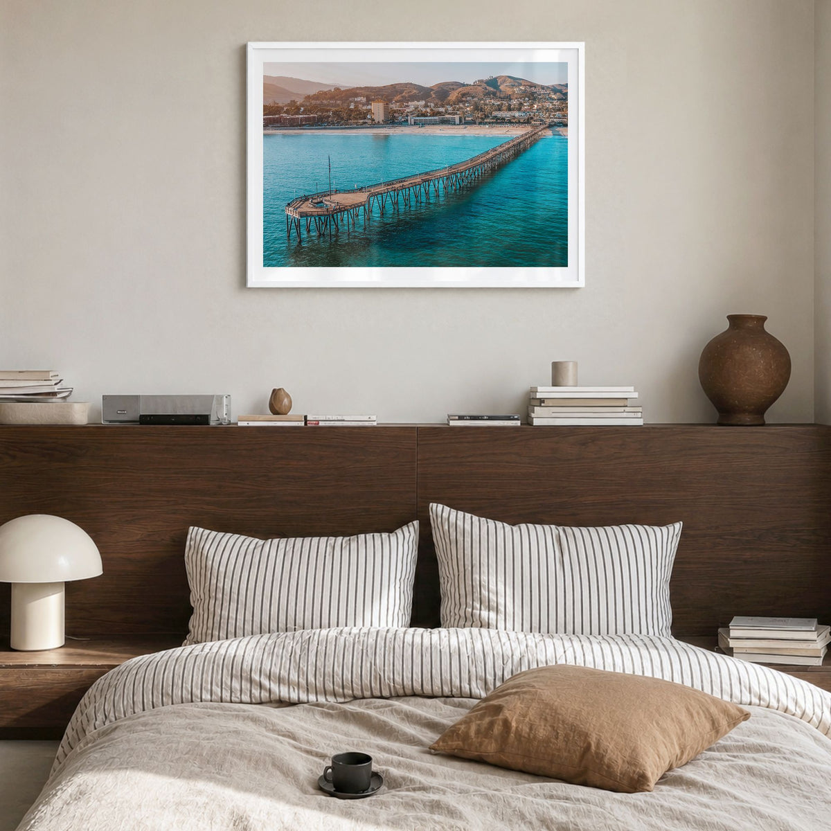 Ventura Photo Poster in a white wood frame, hanging in a bedroom, white border