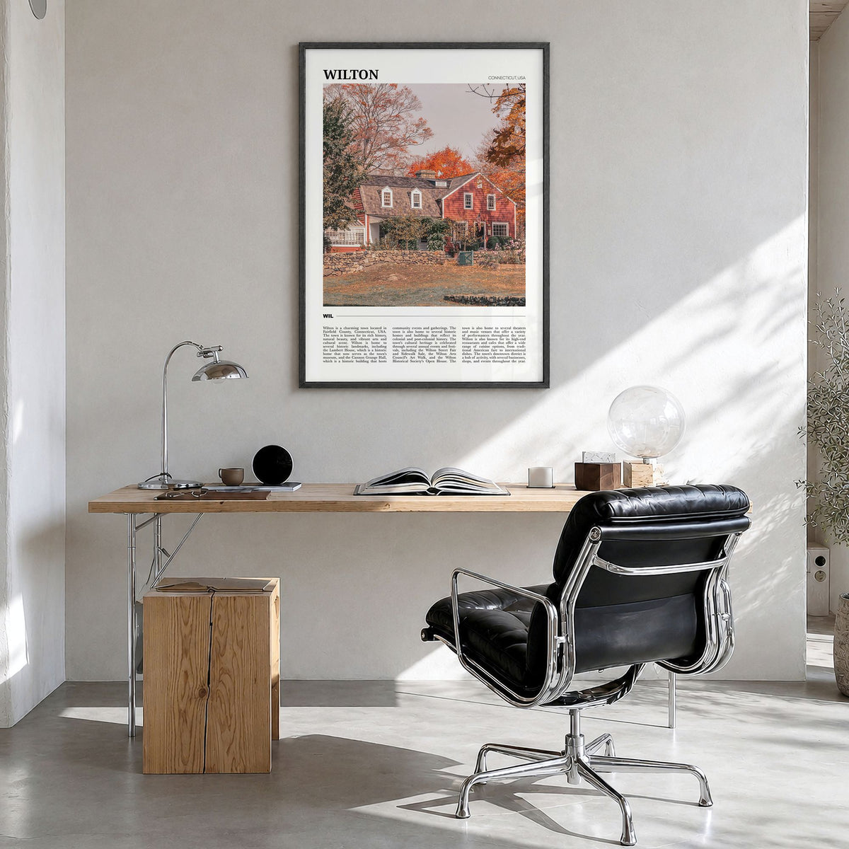 Wilton Travel Poster in a black wood frame, hanging in a bright home office