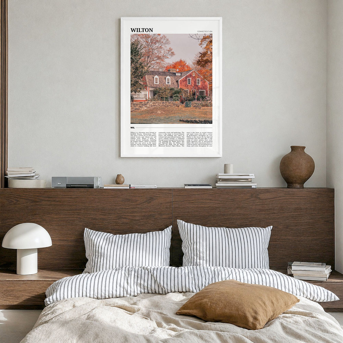 Wilton Travel Poster in a white wood frame, hanging in a bedroom
