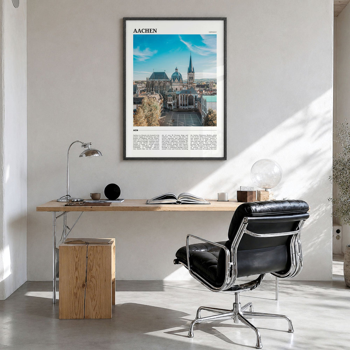 Aachen Travel Poster in a black wood frame, hanging in a bright home office