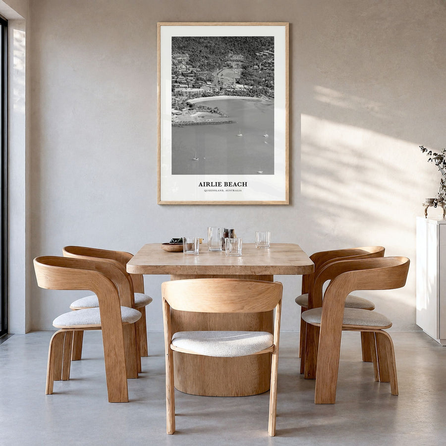 Airlie Beach Classic Poster in a natural wood frame, hanging in a dining room