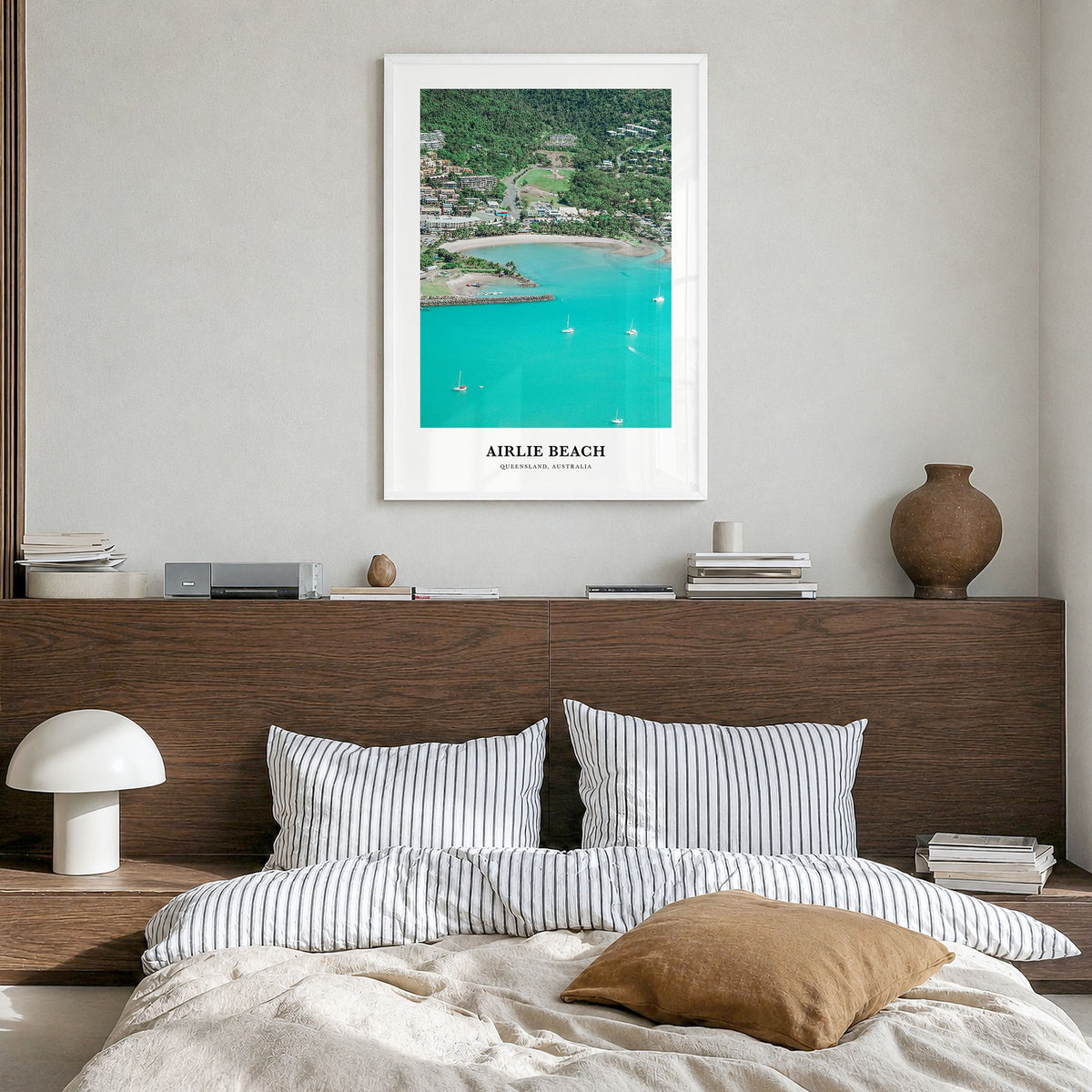 Airlie Beach Classic Poster in a white wood frame, hanging in a bedroom