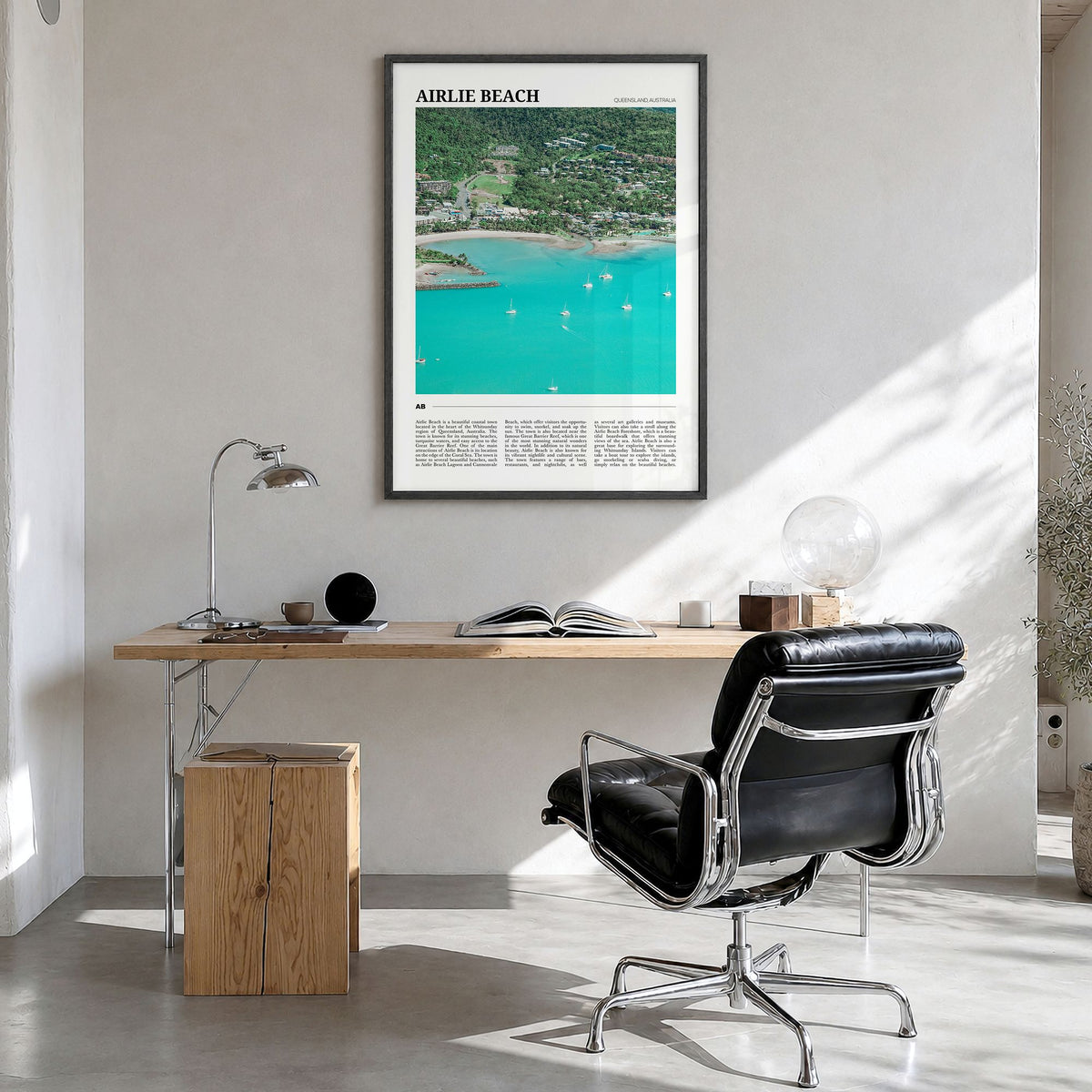 Airlie Beach Travel Poster in a black wood frame, hanging in a bright home office