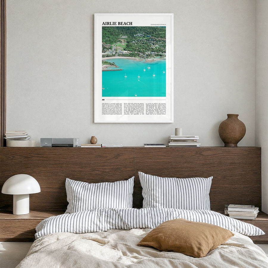 Airlie Beach Travel Poster in a white wood frame, hanging in a bedroom