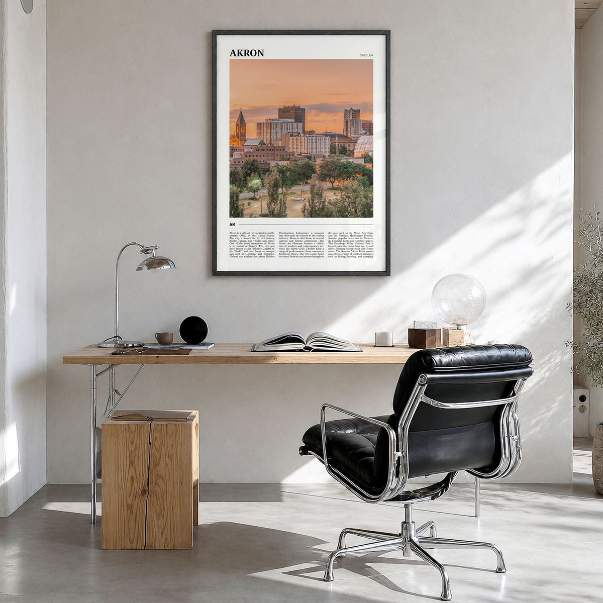 Akron Travel Poster in a black wood frame, hanging in a bright home office